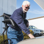 man working on car from standing wheelchair (thumbnail)